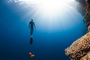 a man in a wet suit swimming in the ocean